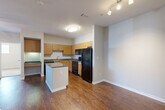 Located at 12430 Oxford Park Dr in Houston, TX, this single-floor, 2-bedroom, 2-bathroom residence offers a practical and well-organized layout. The open-concept kitchen is a central highlight, featuring warm wood cabinetry, dark granite-style countertops, a full suite of black appliances including a range, microwave, and refrigerator, and a freestanding island that provides additional prep and serving space. Rich hardwood-style flooring flows through the kitchen, living, and dining areas, lending a cohesive and polished look throughout the main living spaces. The primary bedroom is a comfortable retreat, fitted with ceiling fan lighting and a sliding glass door that opens to an outdoor area, bringing in natural light and outdoor views. It is complemented by a spacious walk-in closet with wire shelving for ample storage. The second bedroom also features plush carpeting, a ceiling fan, and multiple windows that fill the room with natural light. Both bathrooms are well-appointed with white tile tub-shower combinations and granite-style vanity surfaces. Additional features include three closets, a dedicated laundry area, and a connecting hallway that ties the layout together efficiently. The neutral color palette and consistent finishes throughout create a clean, move-in-ready atmosphere.