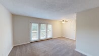 Located at 2041 Shady Grove Way in Louisville, Kentucky, this one-bedroom, one-bathroom unit offers a well-designed and efficiently organized layout across a single floor. The living area features warm, neutral-toned carpet, a ceiling fan, and a set of large windows with a glass door that opens to a private wooden deck, filling the space with natural light and offering pleasant outdoor views of the surrounding greenery. The transition between the carpeted living area and wood-look flooring adds a subtle visual contrast throughout the unit. The kitchen is thoughtfully appointed with crisp white cabinetry, granite countertops, a stainless steel single-basin sink, and an electric range with an overhead ventilation hood — a clean and functional space for everyday cooking. The generously sized bedroom, the largest room in the unit, provides ample space and connects to a dedicated closet for storage. The bathroom features a tub-and-shower combination with elegant marble-style tile surround, a toilet, and wood-look flooring, presenting a clean, modern aesthetic. Neutral wall tones and textured ceilings are consistent throughout, lending the entire unit a bright, cohesive, and move-in-ready feel.