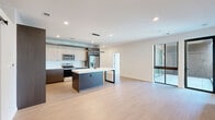 Located at 421 N Pennsylvania St in the heart of Indianapolis, this thoughtfully designed 2-bedroom, 2-bathroom residence offers a clean, contemporary aesthetic throughout. The open-concept living and kitchen area serves as the centerpiece of the home, featuring light hardwood-style flooring, recessed lighting, and large floor-to-ceiling glass doors that invite natural light and provide access to a private balcony. The modern kitchen is appointed with two-tone cabinetry, a white quartz waterfall island with a pendant light fixture, white tile backsplash, and stainless steel appliances. The living area flows seamlessly, creating a spacious and airy atmosphere. The primary bedroom is generously sized with plush carpeting, direct balcony access via sliding glass doors, and a walk-in closet with built-in shelving. The second bedroom also features soft carpeting and ample closet space. Both bathrooms showcase upscale finishes, with the primary bath offering marble-style tile flooring, a large walk-in shower with floor-to-ceiling tile, black-framed glass enclosure, and a floating vanity with white countertops. A dedicated laundry room houses a full-size washer and dryer. A den, utility room, and four closets round out a well-organized and functional floor plan.