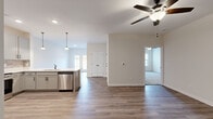Located at 15 Millswood Drive in Clarksville, Tennessee, this single-story, 2-bedroom, 2-bathroom home offers a thoughtfully designed open-concept layout with modern finishes throughout. The kitchen is a standout feature, boasting gray shaker-style cabinetry, a stone tile backsplash, white quartz countertops, a peninsula with an undermount sink and pendant lighting above, and a full suite of stainless steel appliances including a refrigerator, range, microwave, and dishwasher. The kitchen flows seamlessly into the living area, which is finished with durable wood-look luxury vinyl plank flooring and a ceiling fan overhead. Natural light filters in through windows at the front of the home. The spacious primary bedroom is carpeted for comfort and includes a ceiling fan, a walk-in closet, and a dedicated en-suite bathroom. The second bedroom is also carpeted and features a ceiling fan and a window with outdoor views. Both bathrooms are finished with gray vanity cabinetry, dark hardware accents, and wood-look flooring; one includes a tiled tub-shower combo. A dedicated laundry room accommodates a full-size washer and dryer. Two closets provide ample storage throughout the home.