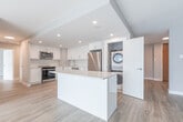 Located at 57 Widdicombe Hill Blvd in Toronto's west end, this well-appointed 2-bedroom, 3-bathroom unit offers a generous and thoughtfully designed single-floor layout. Light-toned luxury vinyl plank flooring runs throughout, complementing the clean, neutral palette of the interiors.

The kitchen is a standout feature, boasting high-gloss white cabinetry, stone-look countertops, stainless steel appliances including a range, over-the-range microwave, and refrigerator, and a double undermount sink. Recessed lighting brightens the space, and a dedicated in-unit stacked washer and dryer adds everyday convenience.

The living room and additional bedroom benefit from expansive floor-to-ceiling windows fitted with roller blinds, allowing abundant natural light and offering elevated views of the surrounding Toronto cityscape. The spacious primary bedroom includes access to a dedicated walk-in closet.

All three bathrooms are finished in a crisp, modern style. One features a full soaker tub with white subway tile surround and chrome fixtures, while the vanities throughout showcase marble-look stone countertops with undermount sinks and large mirrors.

The overall ambiance is bright, clean, and contemporary, making this a functional and visually cohesive space in a convenient Toronto location.