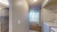 Located in Milwaukie, Oregon, this single-story, 3-bedroom, 1-bathroom home offers a thoughtfully laid-out floor plan with comfortable living spaces throughout. The galley-style kitchen is well-equipped with ample white cabinetry accented by wood trim, generous countertop space, stainless steel refrigerator, dishwasher, and a gas range. Light tile flooring and a window overlooking greenery give the kitchen a bright, functional feel. The living room stands out with soaring vaulted ceilings and a striking arched window that floods the space with natural light and frames lush outdoor views, creating an open and airy atmosphere. Soft carpeting extends throughout the living area and all bedrooms. Each bedroom features a ceiling fan with light fixture and its own closet — including one bedroom with a spacious walk-in closet and another with mirrored sliding-door closet. Baseboard heating is present in select rooms for efficient warmth. The full bathroom includes tile flooring, a vanity with storage, and a tub/shower combination. Textured ceilings are consistent throughout the home, adding a classic touch to this well-maintained residence.