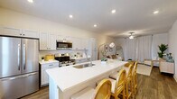 This contemporary single-story residence in West Lafayette offers 1110 square feet of thoughtfully designed living space. The home features three bedrooms, including a spacious 170 square foot primary bedroom, and two well-appointed bathrooms. The open-concept living area showcases a harmonious blend of style and functionality, with a light-filled living room adorned with modern furnishings and artistic accents. The kitchen boasts sleek white cabinetry, stainless steel appliances, and a practical island, perfect for meal preparation and casual dining. Neutral tones and wood-look flooring throughout create a cohesive and inviting ambiance. Additional amenities include a dedicated laundry room with ample storage, three closets for organization, and an attached garage. The property's design emphasizes comfort and efficiency, making it an ideal choice for those seeking a modern living experience in a convenient West Lafayette location.