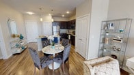 Located at 131 E Bardin Rd in Arlington, Texas, this single-floor residence offers a thoughtfully designed open-concept layout that seamlessly connects the living, dining, and kitchen areas. The kitchen is a standout feature, showcasing rich dark-espresso cabinetry, granite countertops, stainless steel appliances including a refrigerator, range, and built-in microwave, all complemented by wood-look flooring that extends throughout the main living spaces. A kitchen island with pendant lighting serves as a natural gathering point, flowing into the dining area, which is highlighted by a round marble-top table and tufted upholstered chairs. The living room is bright and welcoming, with large windows that invite natural light and offer outdoor views, neutral wall tones, and wood-look flooring. The bedroom is a comfortable retreat featuring plush carpeting, a ceiling fan, and a generous window providing additional natural light. The bathroom is well-appointed with granite countertops, a dark-toned vanity with a framed mirror, and wood-look tile flooring, with convenient access to a walk-in closet outfitted with wire shelving and organizational storage. Throughout the space, neutral tones and modern finishes create a cohesive and inviting atmosphere.