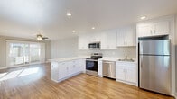 Located at 37811 Fremont Blvd in Fremont, CA, this single-story 2-bedroom, 1-bathroom home offers a well-designed layout with modern finishes throughout. The open-concept kitchen is a standout feature, boasting crisp white shaker cabinetry, bright white countertops, and a full suite of stainless steel appliances including a range, microwave, dishwasher, and refrigerator. Warm-toned hardwood-style flooring runs through the kitchen and living areas, creating a cohesive and inviting atmosphere. The living room is bathed in natural light from a sliding glass door that opens to an outdoor area, and a ceiling fan adds both style and function. Both bedrooms are carpeted and feature ceiling fans, with windows that allow ample natural light to fill each room. The primary bedroom offers a comfortable, well-proportioned space. The bathroom is clean and functional, featuring a full tub-shower combination, a white vanity with sink, and hardwood-style flooring. A hallway connects the main living areas to the bedrooms and bathroom, with two closets providing convenient storage. The home's neutral color palette and updated finishes create a bright, move-in-ready environment.