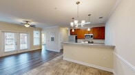 Located at 457 Stone Monument Dr. in Wake Forest, NC, this well-appointed single-floor home offers four bedrooms and two full bathrooms within a thoughtfully designed layout. The open-concept kitchen and living area serves as the heart of the home, featuring warm cherry cabinetry, granite countertops, stainless steel appliances, and pendant lighting over a breakfast bar peninsula. Crown molding and tile flooring add a polished touch to the kitchen space. The living room is bright and inviting, showcasing hardwood-style flooring, crown molding, a ceiling fan, and French doors that invite abundant natural light while providing outdoor access. The bedrooms are well-sized with neutral tones and hardwood-style floors; the primary bedroom is notably spacious and is complemented by a dedicated walk-in closet outfitted with wire shelving and hanging rods for ample storage. The bathrooms mirror the home's design aesthetic, featuring granite-topped vanities with wood cabinetry and tile flooring. A dedicated laundry room with washer and dryer hookups adds everyday convenience. Throughout the home, large windows fill each room with natural light, creating a bright and comfortable living environment.