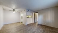 Located at 5803 Preston Oaks Rd in Dallas, TX, this one-bedroom, one-bathroom unit offers a practical and well-organized single-floor layout. Wood-look flooring runs throughout, providing a cohesive and easy-to-maintain surface across all living areas. The open living room is accented by a ceiling fan with light fixture and a textured ceiling, creating a comfortable main gathering space. A pass-through counter connects the living area to the kitchen, which features white cabinetry, a white refrigerator, a range, and a sink with laminate countertops — keeping the cooking space functional and efficient. The bedroom is a well-proportioned private retreat with a window that allows natural light and outdoor views, complemented by the same wood-look flooring. A dedicated walk-in closet off the bedroom provides built-in shelving and hanging rods for organized storage. The bathroom includes a full tub and shower combination with clean white tile surround. Neutral wall tones and consistent flooring throughout lend a unified feel to the space. This unit offers a straightforward, low-maintenance layout well-suited for single occupants or couples seeking convenience in the Dallas area.