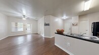 Located in Dallas, TX, this single-story 4-bedroom, 1-bathroom home offers a practical and well-organized layout across its single floor. The open-concept living and dining area is bright and welcoming, featuring warm hardwood-style flooring, ceiling fans, and natural light streaming through blinds-covered windows. A glass-panel door provides direct access to the outdoor patio, adding a seamless indoor-outdoor connection.

The kitchen is efficiently designed in an L-shape configuration, outfitted with rich dark wood cabinetry, granite-style countertops, and black appliances including a refrigerator, gas range, microwave, and dishwasher. A pass-through counter connects the kitchen to the main living area, enhancing the open feel. A dedicated pantry and in-unit laundry room add to the home's convenience.

The four bedrooms are carpeted and receive natural light through individual windows. The primary bedroom offers a comfortable footprint with ample closet space, and three additional closets are distributed throughout the home. The bathroom includes accessibility features such as grab bars, and hardwood-style flooring continues into this space. A connecting hallway ties all rooms together in a coherent, functional floor plan suited for everyday living.