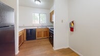 Located at 13400 Lomas Blvd NE in Albuquerque, New Mexico, this single-floor, 2-bedroom, 1-bathroom unit offers a practical and functional layout. The living area features neutral-toned carpet, a ceiling fan with light fixture, and a textured ceiling. It connects seamlessly to the kitchen via a pass-through counter with a granite-style surface, ideal for casual dining or meal prep. The kitchen is equipped with warm wood cabinetry, a double-basin sink, a black gas range, a dishwasher, and durable wood-look flooring. A window above the sink provides natural light and outdoor views. Both bedrooms are carpeted and include ceiling fans. The primary bedroom features a closet with a built-in rod and shelving, while the second bedroom offers a bright window with natural light. A hallway connects the rooms and leads to the full bathroom, which is finished with wood-look flooring, a single-sink vanity with storage cabinets, a toilet, and a tub/shower combo with a white surround. Built-in shelving near the bathroom entry adds additional storage. The layout also includes a dedicated closet and hallway, maximizing the use of the available space throughout the unit.