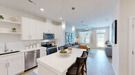 Located at 35205 Tupelo Cir in Frankford, Delaware, this well-designed one-bedroom, one-bathroom residence offers a thoughtfully organized single-floor layout. The open-concept kitchen and living area serves as the heart of the home, featuring crisp white shaker cabinetry, open shelving, stainless steel appliances including a refrigerator, range, microwave, and dishwasher, and a large white island with built-in shelving that doubles as a casual dining space with bar seating. Light wood-tone flooring flows throughout the main living areas, complementing the bright, neutral color palette. The living area is bathed in natural light from oversized windows with views of the outdoors, and is equipped with a ceiling fan for added comfort. The bedroom offers plush carpet flooring, a ceiling fan, and a large window with outdoor views, creating a peaceful retreat. Two closets provide generous storage. The full bathroom features a tub/shower combination, a white vanity, and light wood-tone flooring. Additional functional spaces include a dedicated laundry room and a utility room. Recessed lighting and pendant fixtures throughout add a modern finishing touch to this clean, contemporary residence.
