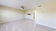 Located in Pinellas Park, FL, this one-bedroom, one-bathroom unit offers a well-organized single-floor layout designed to maximize functionality and comfort. The open living area features light-toned luxury vinyl plank flooring throughout, warm beige walls, a textured ceiling, and a ceiling fan with integrated lighting. A large window with horizontal blinds fills the living space with natural light and offers a pleasant view of surrounding greenery. The kitchen connects to the living area via a convenient pass-through counter with granite-style surfaces, and is equipped with white shaker cabinetry, stainless steel appliances including a gas range, built-in microwave, and refrigerator. The bedroom is a comfortable size, with its own ceiling fan, a sliding glass door providing additional natural light, and access to a dedicated walk-in closet with built-in shelving and hanging rods. The full bathroom features a tub-shower combination with tile surround, a white vanity with a single-basin sink, and a mirrored medicine cabinet. A hallway connects the main spaces, contributing to a logical and efficient flow throughout the unit. Consistent LVP flooring and a neutral color palette tie all areas together for a clean, cohesive interior aesthetic.