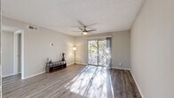 This single-floor, 3-bedroom, 1-bathroom residence in Austin, Texas offers a practical and well-appointed layout throughout. The open living room is a welcoming centerpiece, featuring durable wood-style flooring, a ceiling fan, a textured ceiling, and abundant natural light streaming in through a large sliding glass door that opens onto a private balcony overlooking mature trees. The kitchen is efficiently designed with white cabinetry, white quartz countertops, a stainless steel sink, and a full suite of stainless steel appliances including a refrigerator, range, microwave, and dishwasher, all complemented by a tile backsplash. The bedrooms are comfortably sized, each with wood-style flooring and ceiling fans; the primary bedroom includes a dedicated closet. The full bathroom is finished with gray cabinetry, a white quartz vanity countertop, wood-style flooring, and a shower-tub combination. A hallway connects the main living areas to the bedrooms, and two closets provide additional storage. Neutral gray tones throughout create a cohesive, move-in-ready aesthetic suited for everyday living in the heart of Austin's 78746 zip code.