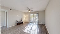 This single-floor, 3-bedroom, 1-bathroom residence in Austin, Texas offers a practical and well-appointed layout throughout. The open living room is a welcoming centerpiece, featuring durable wood-style flooring, a ceiling fan, a textured ceiling, and abundant natural light streaming in through a large sliding glass door that opens onto a private balcony overlooking mature trees. The kitchen is efficiently designed with white cabinetry, white quartz countertops, a stainless steel sink, and a full suite of stainless steel appliances including a refrigerator, range, microwave, and dishwasher, all complemented by a tile backsplash. The bedrooms are comfortably sized, each with wood-style flooring and ceiling fans; the primary bedroom includes a dedicated closet. The full bathroom is finished with gray cabinetry, a white quartz vanity countertop, wood-style flooring, and a shower-tub combination. A hallway connects the main living areas to the bedrooms, and two closets provide additional storage. Neutral gray tones throughout create a cohesive, move-in-ready aesthetic suited for everyday living in the heart of Austin's 78746 zip code.
