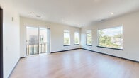 Located in Denver's vibrant LoHi-adjacent neighborhood, this well-appointed 3-bedroom, 2-bathroom single-floor home offers a clean, contemporary design throughout. Light hardwood flooring flows seamlessly across every room, complemented by crisp white walls, dark baseboards, and dark-framed windows that lend a modern aesthetic.

The open-concept living area is spacious and bright, featuring multiple large windows and sliding glass doors that open to a private balcony, filling the room with natural light and offering pleasant views of surrounding greenery. Recessed lighting adds to the airy ambiance.

The kitchen is thoughtfully designed with rich walnut-toned cabinetry, light quartz countertops, a white tile backsplash, and stainless steel appliances including a range, microwave, and dishwasher. A matte black faucet and sink add a refined touch, while a peninsula island provides additional counter space and casual seating.

The primary bedroom is generously sized, with dual windows framing views of the neighborhood's mature trees and a walk-in closet with built-in shelving. The two additional bedrooms are well-proportioned with ample natural light. Both bathrooms feature wood-toned vanities, quartz counters, large framed mirrors, and matte black fixtures, with one offering a soaking tub and stone-tiled surround.
