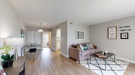 This single-floor residence offers a thoughtfully designed layout that balances comfort and functionality across its key living areas. The open-concept living and dining space is anchored by light-toned hardwood flooring throughout, creating a bright and cohesive feel. The living area features neutral gray walls, a textured ceiling, and a sliding glass door dressed with vertical blinds that floods the room with natural light and provides views of the surrounding greenery. A wall-mounted mirror adds depth, while the adjoining dining area is defined by a pendant light fixture overhead.

The galley-style kitchen is efficiently organized with crisp white cabinetry, light granite-style countertops, a stainless steel sink, and black stainless appliances including a refrigerator and range, all set over matching hardwood flooring.

The bedroom is a calm retreat with plush carpeting, soft neutral tones, and its own sliding glass door offering outdoor views and natural light. An open closet with shelving provides ample storage.

The bathroom is clean and functional, featuring a tub and shower combination, a white vanity, and hardwood-style flooring, completing this well-rounded and move-in-ready space.