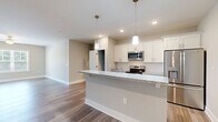 Located at 124 Center Church Rd in Sanford, NC, this single-story, 3-bedroom, 2-bathroom home offers a thoughtfully designed layout with modern finishes throughout. The open-concept living, dining, and kitchen area serves as the heart of the home, featuring wood-look flooring, neutral tones, and abundant natural light from multiple windows. The kitchen is a standout, showcasing white shaker-style cabinetry, a subway tile backsplash, granite countertops, a large island with a built-in sink, stainless steel appliances, and stylish pendant lighting. A pantry provides additional storage. The dining and living area extends seamlessly from the kitchen, with a glass door offering outdoor access and views. The bedrooms are carpeted and equipped with ceiling fans and generous closet space, including built-in shelving. The primary bedroom is comfortably sized with its own closet. The bathrooms are finished with wood-look tile flooring and include a tub-shower combination. A dedicated laundry room houses a full-size washer and dryer with overhead shelving. Additional utility and hallway spaces complete the efficient floor plan, making this home both functional and inviting.