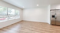 Located at 730 S Kingsley Dr in the heart of Los Angeles, this well-appointed one-bedroom, one-bathroom unit offers a thoughtfully designed layout across a single floor. The open-concept living, dining, and kitchen area creates a bright, cohesive space anchored by light-toned hardwood-style flooring that runs throughout. The kitchen is a standout feature, outfitted with crisp white shaker cabinetry, neutral quartz-style countertops, and a full suite of stainless steel appliances including a gas range, over-the-range microwave, dishwasher, and side-by-side refrigerator with ice and water dispenser. Recessed lighting and a flush ceiling fixture keep the space well-lit and clean in appearance. The bedroom offers a comfortable footprint with natural light streaming through windows fitted with horizontal blinds, providing views of the surrounding neighborhood. A wall-mounted mini-split HVAC unit ensures year-round climate control. The room is equipped with a full-width mirrored sliding closet, adding both storage and a sense of depth. The bathroom features a white vanity with shaker-style cabinetry, a framed mirror, and a tub-shower combination enclosed by sliding glass doors. A dedicated laundry area and two closets round out the functional layout of this clean, modern unit.