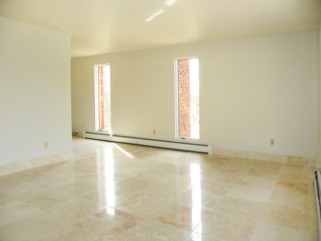 Tall windows let in tons of light to the spacious living room. - 6445 Union Ave