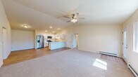 Located at 4395 Christopher Dr in Eau Claire, Wisconsin, this well-designed 2-bedroom, 2-bathroom home offers a comfortable and functional layout across a single floor. The open-concept living room and kitchen area immediately impresses with vaulted ceilings, recessed lighting, and a ceiling fan that enhance the airy, light-filled atmosphere. Durable hardwood-style flooring runs through the kitchen and dining area, while plush carpeting adds warmth to the living and bedroom spaces.

The kitchen is outfitted with white shaker-style cabinetry, stainless steel appliances including a French door refrigerator, electric range, and built-in microwave, along with a peninsula that provides additional counter space and casual dining options. Natural light filters in through multiple windows, brightening the open living area, which also features baseboard heating and a wall-mounted AC unit.

The generously sized primary bedroom includes a ceiling fan and access to a spacious walk-in closet fitted with wire shelving systems for ample storage. The bathrooms feature luxury vinyl plank flooring, white vanities with large mirrors, and bright vanity lighting. A carpeted staircase with a sleek metal handrail leads to additional levels. The second bedroom is well-proportioned and equally bright, completing this move-in-ready home.