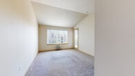 Located at 1133 N Grape Dr in Moses Lake, WA, this one-bedroom, one-bathroom unit offers a practical and comfortable layout across a single floor. The living area features vaulted ceilings that lend a sense of openness, soft carpeting underfoot, and a large window fitted with vertical blinds that allows natural light to fill the space. A wall-mounted HVAC unit provides convenient climate control.

The kitchen is a standout feature, equipped with warm wood cabinetry, granite-style countertops, and a full suite of stainless steel appliances including a dishwasher, electric range with over-the-range microwave, and refrigerator. Hardwood flooring runs throughout the kitchen, adding warmth and easy maintenance.

The bedroom is a comfortable, well-proportioned room with plush carpeting, a large window overlooking the surroundings, and a baseboard heater for added warmth. Neutral-toned walls carry throughout the space, creating a calm and cohesive aesthetic.

The bathroom offers dual sinks set into a granite-style vanity with ample wood cabinetry below, a large mirror with overhead track lighting, and hardwood flooring. An adjacent balcony provides outdoor access, rounding out this well-designed unit in a convenient Moses Lake location.