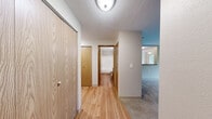 Located on Lawn Courte in Tacoma, WA, this single-floor, 2-bedroom, 2-bathroom residence offers a practical and comfortable layout with thoughtful details throughout. The living room serves as a welcoming centerpiece, featuring plush carpeting, neutral-toned walls, and a classic white-surround fireplace that adds warmth and character to the space. Large windows invite natural light and frame views of the surrounding greenery, creating a serene atmosphere. The kitchen is well-equipped with warm wood cabinetry, gray laminate countertops, a full suite of white appliances, and hardwood flooring that extends into the adjacent dining area. A hallway connects the living spaces to the private quarters, where two carpeted bedrooms offer comfortable retreats. The primary bedroom is generously sized and includes access to lush outdoor views through a large window. Each bathroom features hardwood flooring, a vanity with wood cabinetry and gray countertops, and a shower-tub combination. Two closets provide ample storage throughout the unit. The home's clean, neutral palette and consistent use of natural wood tones create a cohesive and inviting ambiance throughout.