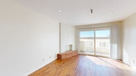 This one-bedroom, one-bathroom residence in Oakland's desirable 94610 neighborhood offers a well-organized, single-floor layout that makes efficient use of its space. Warm hardwood flooring flows consistently throughout, tying each room together with a cohesive, inviting aesthetic.

The combined kitchen and living area forms the heart of the home. The living room is bright and airy, featuring recessed lighting, crisp white walls, and a charming brick fireplace as a standout focal point. A full-width sliding glass door fills the room with natural light and opens to a private balcony, offering pleasant outdoor views.

The galley-style kitchen is well-appointed with rich wood cabinetry — including glass-front upper cabinets — granite countertops, a stainless steel dishwasher, a range, and a refrigerator. Recessed lighting illuminates the generous counter and storage space on both sides of the corridor-style layout.

The bedroom is a comfortably sized, sun-lit room with a window overlooking the exterior and warm hardwood flooring. It is complemented by a dedicated walk-in closet featuring a full-length hanging rod and hardwood floors, providing practical and well-organized storage.

The bathroom includes a full soaking tub with a shower, finished with clean white surrounds and brushed nickel fixtures. The overall ambiance of the residence is clean, bright, and functional.