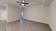 Located at 15 Millswood Rd in Clarksville, Tennessee, this well-appointed 2-bedroom, 2-bathroom single-story home offers a thoughtfully designed open-concept layout. The kitchen and living area form the heart of the home, showcasing crisp white shaker cabinetry, a white subway tile backsplash, stainless steel appliances including a French door refrigerator, gas range, and over-the-range microwave. A center island with a built-in sink and white quartz countertop provides additional prep space and casual seating, illuminated by stylish pendant lighting. Light wood-look flooring flows throughout the main living areas, complemented by a ceiling fan and glass French doors that bring in natural light. Both bedrooms feature plush carpet flooring, ceiling fans, and natural light from well-placed windows. The spacious primary bedroom connects to a private en-suite bathroom with a white quartz vanity, gray cabinetry, and oil-rubbed bronze fixtures. The second full bathroom mirrors the same clean, modern aesthetic. Two dedicated closets offer ample storage. The home's neutral color palette, recessed lighting, and consistent use of quality finishes create a cohesive, move-in-ready atmosphere throughout.