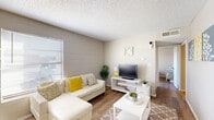 Located at 921 N Zaragoza Rd in El Paso, TX, this single-story 2-bedroom, 1-bathroom home offers a practical and well-organized layout. The living room features wood-look flooring, painted cinder block accent walls, and a textured ceiling, with natural light streaming in through horizontal-blind windows. The combined kitchen and dining area showcases gray cabinetry, a tile backsplash, stainless steel appliances including a range and refrigerator, and a cozy dining nook defined by the same cinder block walls and warm flooring throughout. The bathroom is divided into two functional zones — a vanity area with gray cabinetry and a white countertop, and a separate water closet with a shower-tub combination. Both bedrooms continue the consistent aesthetic of wood-look floors, painted cinder block walls, and textured ceilings, each equipped with a ceiling fan and a closet. Natural light is present in the bedrooms via windows with exterior views. A hallway connects the main living areas to the bedrooms and bathroom, rounding out a compact and cohesive floor plan suited for comfortable everyday living.