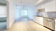 Located at 615 E Carson St in Carson, CA, this one-bedroom, one-bathroom unit offers a thoughtfully designed single-floor layout with a clean, modern aesthetic. The open-concept living and kitchen area features light hardwood-style flooring, crisp white walls, and track lighting overhead, creating a bright and airy atmosphere. A ceiling fan adds both function and comfort to the living space, which is illuminated by a window fitted with roller shades.

The kitchen is well-appointed with white shaker-style cabinetry, dark countertops, a subway tile backsplash, and a full suite of stainless steel appliances, including a range, microwave, and dishwasher. A single-basin sink completes the space.

The bedroom features plush carpeting, roller shade window coverings for privacy, and a ceiling fan, providing a comfortable and restful retreat. A dedicated closet offers practical storage.

The bathroom is finished with a white vanity featuring ample drawer storage, a dark countertop, a large mirror, and a full tub-shower combo with white tile surround. Built-in open shelving provides additional storage convenience. Light hardwood-style flooring continues into the bathroom, tying the space together cohesively. The layout also includes an entrance, hallways, and a dedicated closet, maximizing functionality throughout.