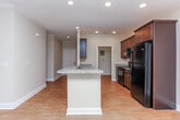 Located at 51 Cohen Walker Dr in Warner Robins, Georgia, this single-story home offers a well-designed layout with a consistent, neutral color palette and quality finishes throughout. The kitchen is a standout feature, showcasing rich dark wood cabinetry, granite countertops, black appliances including a range, microwave, and refrigerator, and a central island with pendant lighting. Wood-look flooring flows through the main living areas, complemented by crown molding and ceiling fans that add a refined touch. A bright living and dining area benefits from natural light through blinds-fitted windows and provides access to an outdoor deck or patio through a glass door. The bedrooms are carpeted and comfortably sized, each featuring ceiling fans and ample natural light. Walk-in closets with wire shelving systems offer generous storage capacity. The bathrooms are well-appointed, with the primary bath featuring a soaking tub, a vanity with granite countertops, dark wood cabinetry, and wood-look tile flooring. A secondary bath includes a tub-shower combination with built-in shelving. A dedicated laundry room with wood-look flooring and utility hookups rounds out the functional layout of this move-in-ready home.