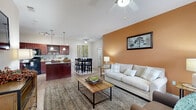 This single-story, 2-bedroom, 2-bathroom home offers a thoughtfully designed open-concept layout that seamlessly connects the kitchen, dining, and living areas. The living room stands out with soaring vaulted ceilings, a ceiling fan, and light-toned hardwood-style flooring, while a bold accent wall adds a warm, inviting character. Windows allow natural light to fill the space, enhancing the airy atmosphere.

The kitchen is well-equipped with rich cherry-wood cabinetry, black appliances including a full-size refrigerator, electric range, and built-in microwave, complemented by a stylish tile mosaic backsplash and granite-style countertops. The adjacent dining room provides a defined space for meals and is conveniently located near a dedicated laundry room with full-size washer and dryer hookups.

The primary bedroom is generously sized with plush carpeting and direct sightlines to the kitchen, while both bathrooms feature matching cherry-wood vanities, granite-style countertops, and wood-look tile flooring. Two closets, including a walk-in with wire shelving, offer ample storage. The home also includes an attached garage with an automatic opener, completing this practical and comfortable residence.