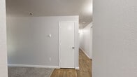 Located at 3701 S Orchard St in Tacoma, WA, this single-floor, 3-bedroom, 2-bathroom unit offers a practical and well-organized layout. The floor plan connects three carpeted bedrooms through a central hallway, providing a comfortable flow throughout the home. Each bedroom features neutral gray walls, plush carpet flooring, and windows that allow natural light to filter in. The primary bedroom stands out with its dedicated closet space, baseboard heating, and a sliding glass door that opens to a view of the landscaped outdoor surroundings. Additional bedrooms include sliding panel closets and windows overlooking greenery and natural rock features outside. The two bathrooms are finished with warm wood-look vinyl flooring, white cabinetry with brushed nickel hardware, single-basin vanities, and full tub-shower combinations — offering clean, functional spaces. A dedicated closet and hallway with hardwood-style flooring round out the unit's storage and circulation needs. The unit also features an electrical panel integrated into one of the bedroom spaces, adding convenience. Overall, the home presents a clean, neutral palette throughout, making it a versatile and move-in-ready space in the Tacoma area.