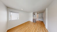 Located at 16210 NE 80th St in Redmond, WA, this efficiently designed unit makes the most of its single-floor layout, incorporating a kitchenette, bathroom, and open living area into a cohesive, functional space. Light wood-tone vinyl plank flooring runs throughout, lending warmth and visual continuity across every area.

The main living space features crisp white walls and is illuminated by natural light streaming through multiple windows fitted with horizontal blinds, offering views of the surrounding Redmond neighborhood. A flush ceiling light fixture provides additional overhead illumination.

The kitchenette is neatly integrated along one wall and features dark wood-grain cabinetry — both upper and lower — paired with a light stone-tone countertop and a stainless steel sink. Open shelving adjacent to the kitchen provides convenient storage and organizational flexibility.

The bathroom is clean and straightforward, equipped with a shower/tub combination, a toilet, a vanity with a mirror, and brushed nickel hardware including a towel bar and toilet paper holder. White walls keep the space feeling bright and tidy.

Overall, the unit presents a clean, modern aesthetic with a neutral palette, making it a practical and move-in ready space in the heart of Redmond, WA.