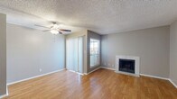 This well-laid-out two-bedroom, two-bathroom residence in Corpus Christi, TX offers a comfortable and functional single-floor layout. The open living room is a welcoming centerpiece, featuring warm wood-look hardwood flooring, a ceiling fan, a tiled fireplace, and a sliding glass door with vertical blinds that allows an abundance of natural light to fill the space. The adjoining galley-style kitchen is efficiently designed with white cabinetry, light countertops, a tile backsplash, a stainless steel sink, and an electric range, providing ample workspace for everyday cooking. A hallway connects the main living areas to both bedrooms, each finished with plush carpeting and windows with blinds that let in natural light. The primary bedroom includes a dedicated closet and direct access to its own bathroom. The second bedroom is generously sized with its own closet and easy access to the second full bathroom. Both bathrooms are clean and functional, each featuring a tub-shower combination with tiled surrounds, wood-look flooring, and vanity storage. A textured ceiling is consistent throughout the home. The layout is completed by a hallway providing convenient access to all rooms.