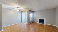 This well-laid-out two-bedroom, two-bathroom residence in Corpus Christi, TX offers a comfortable and functional single-floor layout. The open living room is a welcoming centerpiece, featuring warm wood-look hardwood flooring, a ceiling fan, a tiled fireplace, and a sliding glass door with vertical blinds that allows an abundance of natural light to fill the space. The adjoining galley-style kitchen is efficiently designed with white cabinetry, light countertops, a tile backsplash, a stainless steel sink, and an electric range, providing ample workspace for everyday cooking. A hallway connects the main living areas to both bedrooms, each finished with plush carpeting and windows with blinds that let in natural light. The primary bedroom includes a dedicated closet and direct access to its own bathroom. The second bedroom is generously sized with its own closet and easy access to the second full bathroom. Both bathrooms are clean and functional, each featuring a tub-shower combination with tiled surrounds, wood-look flooring, and vanity storage. A textured ceiling is consistent throughout the home. The layout is completed by a hallway providing convenient access to all rooms.