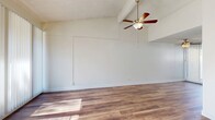 Located at 1125 Pine Ave in Redlands, CA, this two-bedroom, one-bathroom single-story home offers a functional and well-appointed layout across a comfortable footprint. Rich wood-look flooring flows consistently throughout, lending warmth and cohesion to every room.

The living room is a standout space, featuring vaulted ceilings, a ceiling fan with light fixture, and textured ceiling detail. Large sliding glass doors with vertical blinds invite abundant natural light and open to a private patio, seamlessly connecting indoor and outdoor living.

The kitchen is outfitted with white cabinetry, dark granite-style countertops, a stainless steel double sink, and a full-size refrigerator. A window with vertical blinds provides natural light, making the space feel open and functional.

Both bedrooms are bright and well-sized, each featuring ceiling fans, windows with vertical blinds, and wall-unit air conditioning. The primary bedroom offers generous proportions and ample closet access. Three closets are distributed throughout the home, providing excellent storage.

The bathroom features a dark granite vanity with white cabinetry, wood-look flooring, and grab bars for added accessibility. A hallway connects the main areas of the home, completing this practical and inviting single-floor layout.