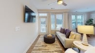 This single-floor residence offers a thoughtfully designed layout that balances comfort and modern style throughout. The open-concept living area features wood-look flooring, a ceiling fan, and direct access to an outdoor balcony through glass-paned doors, with generous windows allowing abundant natural light to fill the space. Adjacent to the living room, the dining area occupies a sun-drenched corner framed by multiple large windows with wood blinds and sheer curtains, creating a bright and inviting atmosphere for meals. The kitchen is well-equipped with rich dark cabinetry, granite-look countertops, a tiled backsplash, and a full suite of stainless steel appliances including a gas range, over-range microwave, and refrigerator. The primary bedroom provides a calm retreat with plush carpeting, a ceiling fan, and a dresser nook, while the second bedroom also features carpet flooring and dual windows with outdoor views. Both bathrooms showcase granite countertops, undermount sinks, dark cabinetry, glass-enclosed showers with tile surround, and large mirrors. The overall aesthetic throughout the residence is clean and contemporary, with neutral tones and quality finishes that lend a polished, move-in-ready feel.