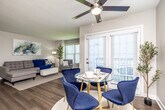 This thoughtfully designed 2-bedroom, 2-bathroom single-floor residence offers a comfortable and functional layout across a well-utilized footprint. The open-concept living, dining, and kitchen area forms the heart of the home, featuring warm hardwood-style flooring and large windows fitted with plantation shutters that fill the space with natural light. The living room provides a relaxed atmosphere with a textured ceiling and ample room for seating arrangements. The dining area opens directly to the outdoors through French doors, enhancing the sense of space and connectivity.

The kitchen is well-equipped with gray shaker-style cabinetry, granite countertops, a white subway tile backsplash, and a full suite of stainless steel appliances including a refrigerator, range, microwave, and dishwasher. Hardwood-style flooring and a louvered utility closet complete the kitchen's practical design.

Both bedrooms feature plush carpet flooring, large windows with natural views, and generous walk-in closets outfitted with wire shelving systems. The primary bedroom offers a notably spacious layout. Each bathroom is finished with a wide vanity, white countertops, gray cabinetry, and wood-style flooring. A connecting hallway ties the private areas together efficiently, completing this cohesive and move-in-ready residence.