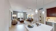 This single-story residence is designed with an open, flowing layout that connects the main living spaces seamlessly. The living room serves as the centerpiece, featuring light porcelain tile flooring, a ceiling fan, and a large window dressed with floor-to-ceiling drapes that allow natural light to fill the room. Pendant lighting and a track lighting system illuminate the open-plan dining and living areas, which transition naturally into each other.

The kitchen is outfitted with rich cherry wood cabinetry extending to the ceiling, stainless steel appliances including a French door refrigerator, built-in microwave, and range, paired with light quartz countertops and a single-basin undermount sink.

The primary bedroom features a textured accent wall, plush carpeting, and direct access to an en-suite bathroom equipped with a glass-enclosed walk-in shower and warm stone-tiled walls. A spacious walk-in closet with wire shelving provides ample storage. The second bedroom is bright and carpeted, with a large window and serene, neutral finishes. The second bathroom includes a soaking tub with stone tile surround. Throughout, the space maintains a clean, neutral palette with warm wood accents.