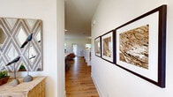Located on Barrow Crossing Boulevard in Bethlehem, GA, this well-appointed two-story home offers a thoughtfully designed layout across two floors. The main level features an open-concept kitchen and living area, where white shaker cabinetry, granite countertops, stainless steel appliances, and a breakfast bar island create a functional and stylish hub for daily living. The adjacent living room is bright and inviting, with recessed lighting, a ceiling fan, and warm hardwood-style flooring that carries throughout the home. A secondary living area on the main floor provides flexible space ideal for a home office or lounge, with multiple windows offering views of the lush, fenced backyard framed by mature Georgia pines. Upstairs, the primary bedroom offers a generous walk-in closet with built-in shelving, while additional bedrooms feature natural light and ample space. All three bathrooms are finished with granite-topped vanities, white cabinetry, and hardwood-style flooring. A dedicated laundry room with wire shelving and washer/dryer hookups adds everyday convenience. The private, fenced backyard with a gated wood fence and open green space completes this comfortable and well-rounded home.