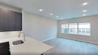 This contemporary apartment at The Lofts At Gloucester offers a thoughtfully designed living space of 1,000 square feet. The floor plan features two bedrooms and three bathrooms, providing ample space and privacy. The primary bedroom, measuring 180 square feet, offers a generous retreat.

The apartment showcases a modern aesthetic with clean lines and neutral tones. Light wood flooring runs throughout, complementing the crisp white walls and creating a bright, airy atmosphere. Recessed lighting adds to the contemporary feel while providing even illumination.

Large windows in the living areas and bedrooms allow natural light to flood the space, offering views of the surrounding area. The open-concept layout promotes a sense of spaciousness and flow between rooms.

The bathrooms feature sleek designs with dark wood vanities, white countertops, and modern fixtures. Tiled flooring and glass shower enclosures add to the upscale ambiance.

Storage is a key feature, with built-in closet systems and additional cabinet space in the bathrooms. The overall design prioritizes functionality without sacrificing style, making this apartment an ideal urban living space.