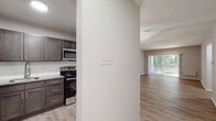 Located at 366 Schraffts Drive in Waterbury, Connecticut, this single-floor residence offers a thoughtfully designed layout with modern finishes throughout. The open living and dining area is bright and welcoming, featuring light wood-look luxury vinyl flooring and a stylish geometric pendant light fixture. A full-width sliding glass door floods the space with natural light and provides views of the surrounding greenery, creating a seamless connection to the outdoors. Baseboard heating is present throughout, ensuring year-round comfort.

The kitchen is outfitted with dark shaker-style cabinetry, granite-look countertops, and a full suite of stainless steel appliances, including a refrigerator, electric range, and built-in microwave. The light flooring continues into the kitchen, complementing the contemporary design.

The bedrooms feature plush wall-to-wall carpeting in neutral tones, with windows that invite natural light and offer views of the tree-lined surroundings. Ample closet storage is provided via full-width bifold doors. A connecting hallway with additional closet space links the living areas to the private rooms.

The bathroom is finished with wood-look flooring, a white vanity, and a tiled walk-in shower featuring marble-patterned wall tiles, providing a clean and modern aesthetic throughout.