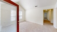 Located at 9310 River Haven Pl in Raleigh, NC, this single-floor residence offers three bedrooms, two full bathrooms, and a practical, well-organized layout. The galley-style kitchen features light wood cabinetry, a coil-burner electric range, a full-size refrigerator, a single-basin sink, and durable wood-look flooring — all complemented by overhead lighting and ample cabinet storage on both sides of the corridor. The kitchen flows directly into the combined living room area, which continues the wood-look flooring for a cohesive feel. Each of the three bedrooms is carpeted and finished in neutral tones, providing a comfortable and quiet retreat. The primary bedroom is a well-proportioned space with carpet flooring, a closet, and access to the hallway. Secondary bedrooms feature large windows with blinds that invite natural light and views of the surrounding greenery. Both bathrooms are equipped with full tub and shower combos featuring chrome fixtures and clean white surrounds, with wood-look flooring tying each room together. A dedicated laundry room includes washer and dryer hookups, overhead wire shelving, and hard flooring for added convenience. A hallway and closet complete the layout, making efficient use of every square foot.