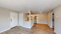 Located at 2821 Pheasant Hollow Dr in Plainsboro, NJ, this one-bedroom, two-bathroom unit offers a well-designed single-floor layout that makes efficient use of its space. The open-concept living and kitchen area serves as the heart of the home, with warm hardwood-style flooring flowing throughout. The kitchen is equipped with stainless steel appliances, including a refrigerator and dishwasher, white shaker-style cabinetry, a tile backsplash, and a granite-topped breakfast bar that connects seamlessly to the living area. The living room is bright and airy, featuring neutral-toned walls and sliding glass doors that open to a private balcony with outdoor views. The bedroom offers a comfortable footprint with a natural light source from a window with blinds and continued hardwood-style flooring. Both bathrooms are finished with clean, modern fixtures, and one includes a stacked in-unit washer and dryer, adding everyday convenience. A dedicated closet and hallway complete the layout, keeping the space organized and functional. The overall ambiance is light, clean, and move-in ready, with a consistent neutral palette throughout.