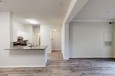 Located at 10207 Baltimore Ave in College Park, Maryland, this one-bedroom, one-bathroom unit offers a well-designed single-floor layout with a cohesive, modern aesthetic throughout. Wood-style plank flooring flows seamlessly across the living, dining, and kitchen areas, creating a unified and easy-to-maintain living space.

The open-concept kitchen is a standout feature, equipped with white shaker-style cabinetry, granite countertops, a subway tile backsplash, and stainless steel appliances including a gas range, dishwasher, and refrigerator. A peninsula with a built-in sink and additional counter space extends into the living and dining area, making it ideal for both cooking and casual entertaining.

The combined living and dining room is bright and open, with crown molding adding a refined touch and a sliding glass door providing access to an outdoor area with greenery views. The bedroom offers natural light through a window, a ceiling fan, and the convenience of two closets, including a walk-in.

The bathroom features a granite-topped vanity with white cabinetry, a large mirror, and a tub-shower combination. A dedicated in-unit laundry area with a washer and shelving provides added practicality. A hallway connects all rooms efficiently, completing this functional and well-appointed home.