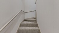 Located at 2800 Pontiac Drive in Aurora, IL, this two-story, two-bedroom, two-bathroom home offers a well-organized and functional layout across its two levels. The main living level features a combined kitchen and living room area, where vaulted ceilings and multiple windows — including transom-style upper panes and a sliding glass door — fill the space with natural light and create an airy, open atmosphere. The kitchen is equipped with stainless steel appliances, including a full-size refrigerator and dishwasher, complemented by light wood-look flooring and dark countertops with white cabinetry. A staircase with a wood railing leads to the upper level, which hosts both bedrooms, two full bathrooms, a dedicated laundry area, and a walk-in closet. The bedrooms are carpeted and feature windows with views of the surrounding greenery, providing a calm and comfortable retreat. The walk-in closet includes wire shelving for organized storage. The bathrooms feature light wood-look flooring, a vanity with stone-look countertops, and a tiled shower-tub combination with chrome fixtures. The in-unit laundry area accommodates a full-size side-by-side washer and dryer. Overall, the home presents a clean, neutral palette throughout.