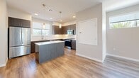 Located at 1725 Montage Avenue in Chula Vista, California, this modern three-story home offers 1,640 square feet of thoughtfully designed living space across three floors. The ground floor (300 sq ft) features an attached garage with automatic opener, strip lighting, and a clean concrete floor. The main living level (690 sq ft) showcases an open-concept kitchen and living room highlighted by light hardwood-style flooring, a sleek linear fireplace, and French doors that invite abundant natural light and outdoor views of palm-lined surroundings. The contemporary kitchen is appointed with dark wood cabinetry, white quartz countertops, a center island, stainless steel appliances, pendant lighting, and recessed lighting. The upper floor (650 sq ft) houses three bedrooms, including a 200 sq ft primary bedroom with carpet flooring, an en-suite bathroom with dark cabinetry vanity, and a dedicated closet. Additional bedrooms feature light hardwood flooring, sliding closet doors, and large windows. The home includes five bathrooms total, each featuring wood-style flooring and marble-look countertops, along with a dedicated laundry area, two staircases, and multiple hallways ensuring seamless flow throughout the residence.