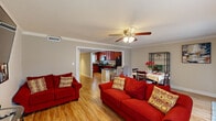 This single-story residence in Metairie, Louisiana, offers a thoughtfully designed layout with two bedrooms and one bathroom. A welcoming entry hallway with wood-look flooring leads into the main living areas, setting the tone for the home's clean, functional aesthetic throughout.

The open-concept living and dining area is finished with light hardwood-style flooring, crown molding, and a ceiling fan, creating a bright and comfortable gathering space. Large windows allow ample natural light to filter in, while a sliding glass door in the dining area provides outdoor access. The living room offers generous space for seating and entertainment.

The kitchen is efficiently designed with rich cherry wood cabinetry extending to the ceiling, dark granite countertops, and black appliances including a refrigerator, dishwasher, and range. A peninsular counter connects the kitchen to the adjoining living area, enhancing the open flow.

Both bedrooms are carpeted for comfort, each featuring ceiling fans, natural light from sizable windows, and a relaxed, restful ambiance. The full bathroom includes a tub-shower combination with hardwood-style flooring and a dark granite vanity top.