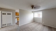 Located at 3715 Third Ave E in Tuscaloosa, Alabama, this single-story unit offers a practical and straightforward layout designed for comfortable everyday living. The living area is finished with wall-to-wall carpeting and features a ceiling fan with a light fixture overhead, along with a textured ceiling. A window with blinds allows natural light to brighten the space, and an open passage connects the living area directly to the kitchen, creating an accessible flow between the two rooms.

The kitchen is outfitted with warm honey-toned wood cabinetry providing ample storage, dark laminate countertops, and a stainless steel sink. White appliances, including a gas range and refrigerator, are included. The kitchen floor features wood-look vinyl planking, adding a practical and easy-to-maintain surface.

The bedroom is carpeted and offers a window with blinds for natural light, along with a sliding-door closet equipped with a hanging rod for storage. Additional closet space is visible in the layout, providing further organizational options. Two doors in the bedroom area offer access to other parts of the unit.

The bathroom is clean and functional, featuring a vanity with a granite-style countertop, wood cabinetry, a wall-mounted mirror, tile surround, and a shower-tub combination. The overall ambiance of the unit is neutral and move-in ready, with a simple, understated aesthetic throughout.
