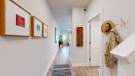 This thoughtfully designed two-story home offers 2 bedrooms and 3 bathrooms across two well-proportioned floors. The entry hallway sets a welcoming tone, featuring light wood-look flooring, crisp white walls, and curated wall art that leads you into the heart of the home. The combined kitchen and living area anchors the main floor, where the kitchen stands out with white shaker cabinetry, a large quartz-topped island with bar seating, stainless steel appliances, and recessed lighting. The adjacent living room is bright and inviting, with natural light streaming through windows and a clean, modern aesthetic. A pantry and laundry room add practical convenience on the main level. Upstairs, the bedrooms offer a comfortable retreat, with plush carpeting, generous natural light, and ample closet space — the primary bedroom benefiting from its own well-appointed en-suite bathroom featuring a glass-enclosed shower, white vanity, and wood-look tile flooring. Additional bathrooms are finished with white cabinetry, quartz countertops, and tub-shower combinations. With six closets distributed throughout, storage is plentiful. The overall ambiance is clean, modern, and move-in ready, with consistent finishes that create a cohesive and functional living environment across both floors.